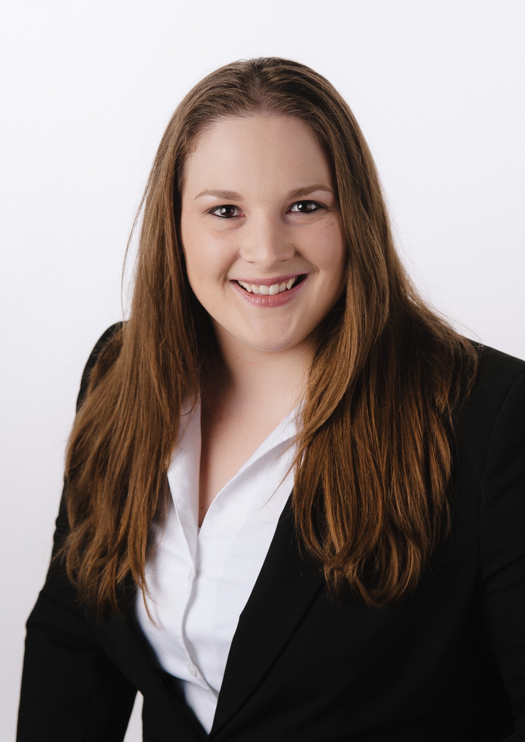 Woman smiling with a white dress shirt and blazer