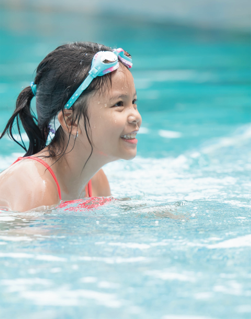 Little girl with goggles in a pool