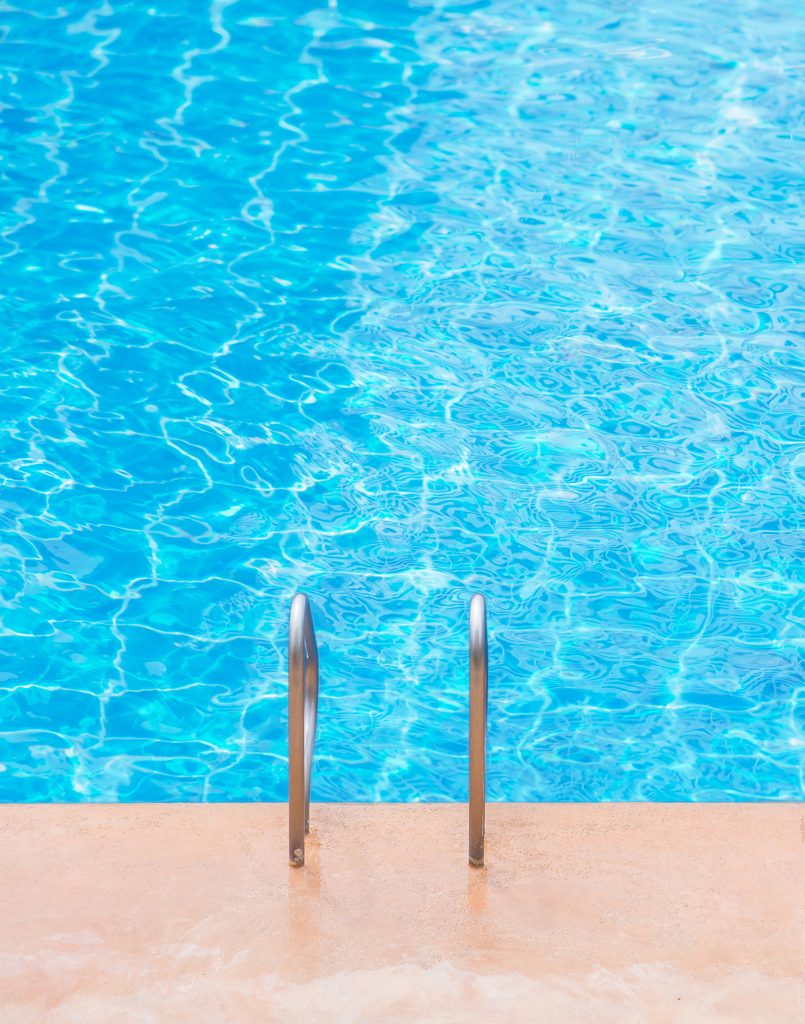 Blue swimming pool at hotel with stair.